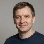 Улыбающийся мужчина средних лет, подтверждающий приверженность Mitra Jaya Teknik принципам ответственной игры в слотах
